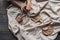 A close-up view of clay plates and a paint brush on a wooden table and dried flowers on a background. Crafted tableware