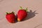 Close-up view of couple ripe juicy strawberries on wooden background with stripes.