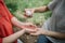 Close-up view of cropped people disinfecting hands with antiseptic spray