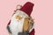 Close up view of a cute figure of Santa Claus with skis and a bag of gifts behind his back.
