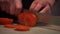 Close up view of cutting large tomato on thin slices. Slicing large red tomato with a knife