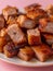 Close up View of Delicious Crispy Pork Belly on a Plate with a Pink Background