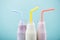 Close-up view of delicious fruity milkshakes in glass bottles with drinking straws