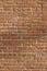 Close-up view of a deteriorating old red clay brick wall texture