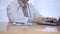 Close up view of doctor working using laptop. Male medic typing on keyboard of notebook