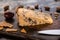 Close up view of dorblu cheese with crackers and knife on wooden cutting board