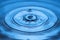 Close up view of Drops making circles on blue water surface isolated on background