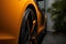 Close-up View of Electric Sports Car from Rear Side. Orange color. Alloy wheels.