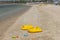 Close up view of empty two yellow inflatable pools and toys for sand on beach.