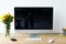 close up view of empty workplace with blank computer screen, keyboard, computer mouse and bouquet of chrysanthemum flowers