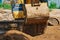 Close up view of an excavator bucket full of earth. The process of digging soil at a construction site. Selective focus