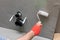 A close-up view of an experienced construction worker applying damp insulation using a paint roller on a wall