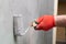 A close-up view of an experienced construction worker applying damp insulation using a paint roller on a wall