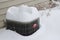 Close up view of an exterior air conditioning unit covered with deep snow