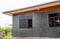 Close-up view of the exterior corner of the house behind a gray concrete wall