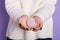 Close up view of faceless woman wearing white shirt holding hydiene product, making choice to use menstrual cup or not, posing