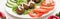 Close up view of falafel with sauce on plate with sliced vegetables on white background, panoramic shot.