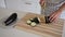 Close-up view of female hands cutting eggplant on chopping board in kitchen