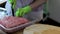 Close up view of female hands in green gloves working with chopped meat in  bowl.