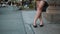 Close-up view of female legs. Young woman standing in the downtown, holding bags after shopping. Slow motion.