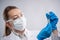 Close-up view of female microbiologist in biohazard protective clothing explore biological tube with vaccine. White background.