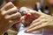 Close up view of female nail painting. Manicurist applying transparent varnish on forefinger nail during final step of