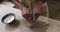 Close up view of female potter wearing apron working on clay to create pot at pottery studio