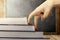 Close up view of fingers hand climb the book steps on wooden table with blackboard background