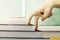 Close up view of fingers hand climb the book steps on wooden table with chalkboard background