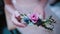 Close-up view of florist woman holding the flower composition in her hand. Girl touching the beautiful buttonhole.