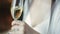 Close-up view of foaming glass with champagne in the hands of a european brunette bride with long hair in a wedding