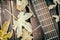 Close-up view of a fragment of acoustic classical guitar with fall maple leaf on wooden background. Autumn concept