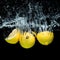 close up view of fresh lemons in water with splashes