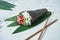 Close up view on fresh, seafood temaki sushi with tuna on white background. Traditional hand roll. Horizontal, selective focus