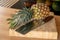 Close-up view of a fresh whole pineapple fruit and a cleaver on a cutting board