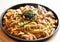 Close-up view, Fried yakisoba with tomato sauce with kurobuta pork on a black round plate.