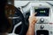 Close up view of front control panel. Woman in casual clothes is sitting in her automobile at daytime