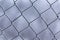 Close up view of Frozen metal fence frost covered in cloudy winter day. Soft focus