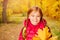 Close-up view of girl with rucksack and maple leaf