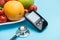 Close up view of glucometer and stethoscope with tomatoes and fruits