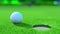 Close up view of a golf ball on the green near the hole