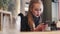 Close up view of gorgeous blonde girl in a casual wear texting online in the cafÃ©. Fashionable outlook, red lips