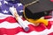 Close-up view of graduation mortarboard and diploma on US flag