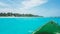 Close up view of green canoe nose with tropical island in the background. Crystal clear tortoise water and blue sky on a sunny day