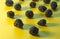 Close up view of a group of blackberries on a yellow background