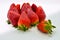 Close up view of a group of several tasty fresh red strawberries just harvested and ready to be eaten. The strawberries are put