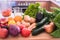 Close-up view of a group of vegetables. In the background the blender filled with small pieces of fruit for a healthy smoothie