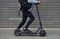 Close up view of guy in casual clothes that riding electric schooter outdoors at sunny daytime