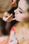 Close-up view of the hand of the artist doing the make-up for the bride.