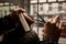 Close-up view of hands of barber master making haircut to client